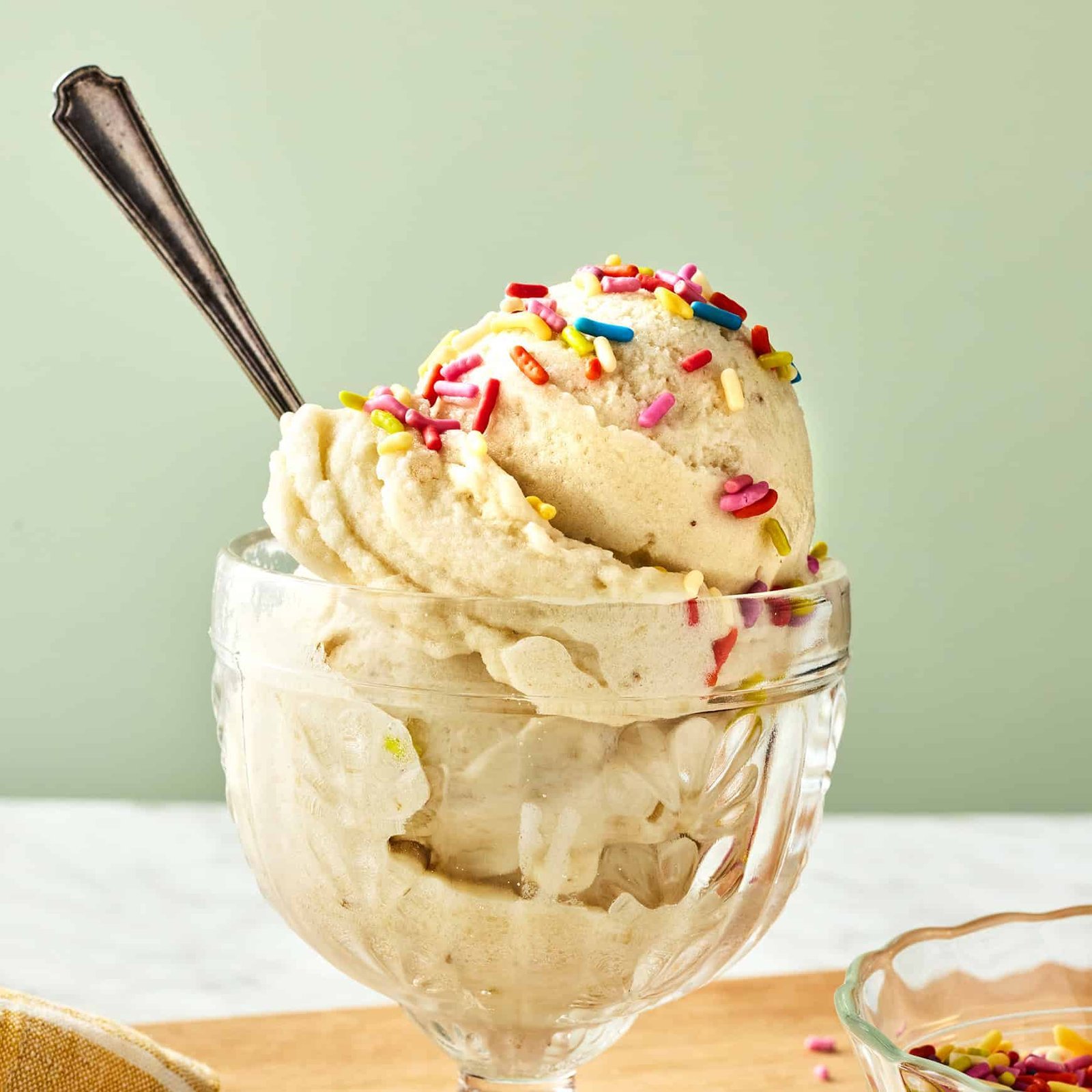 A food processor bowl shows the blending process for banana ice cream.