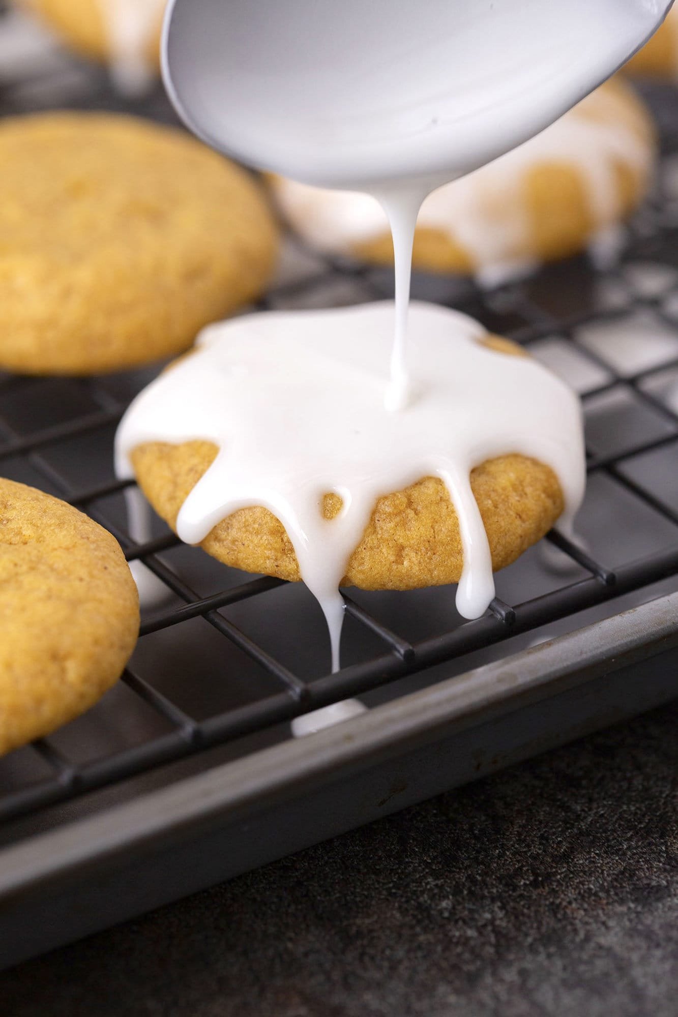 A home baker whisking powdered sugar and liquid in a bowl to make icing.