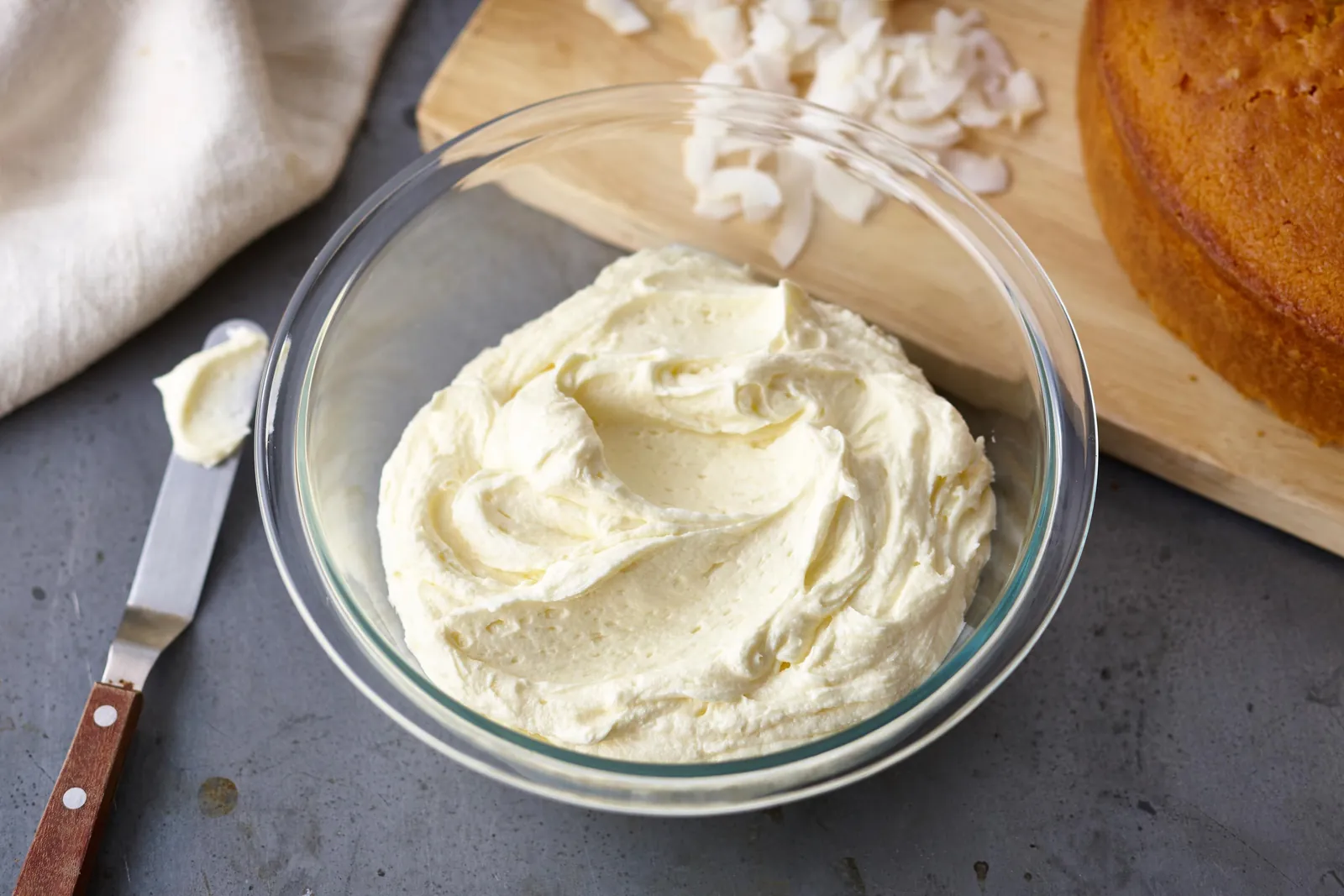 A stainless steel bowl containing perfectly whipped butter icing for home baking.