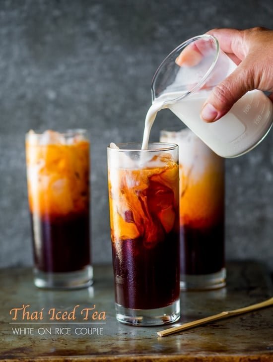 Straining brewed tea through a fine mesh filter for a smooth Thai iced tea.