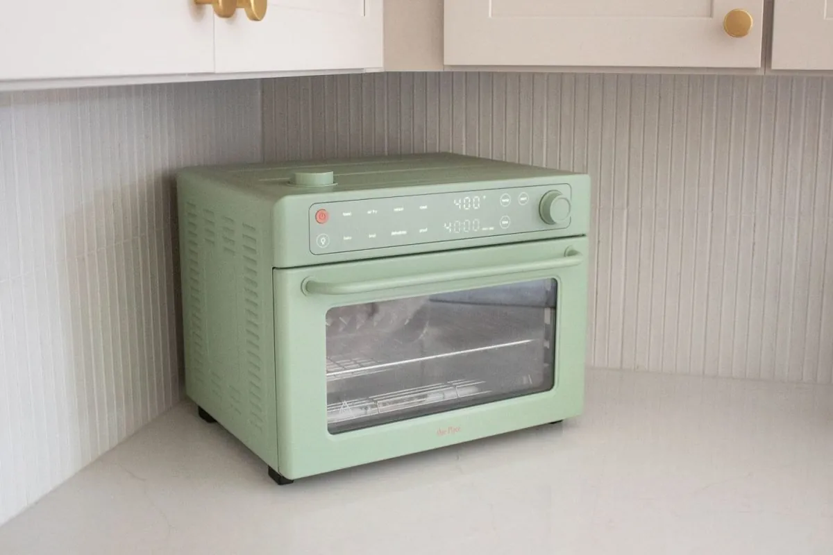 Happy home cooks serving stew from a safe non toxic pot in a bright modern kitchen setting.