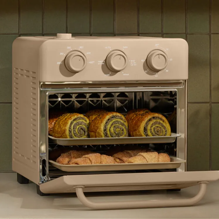 People exploring a wonder oven in a bright kitchen setting with natural lighting.