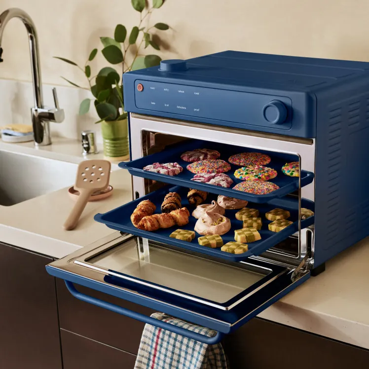Small Wonder Oven beside a large open full-size oven in a kitchen