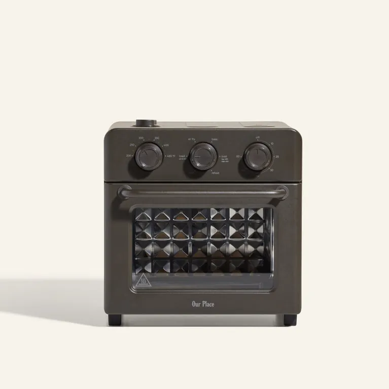 Whole pizza in a large oven next to a small countertop oven